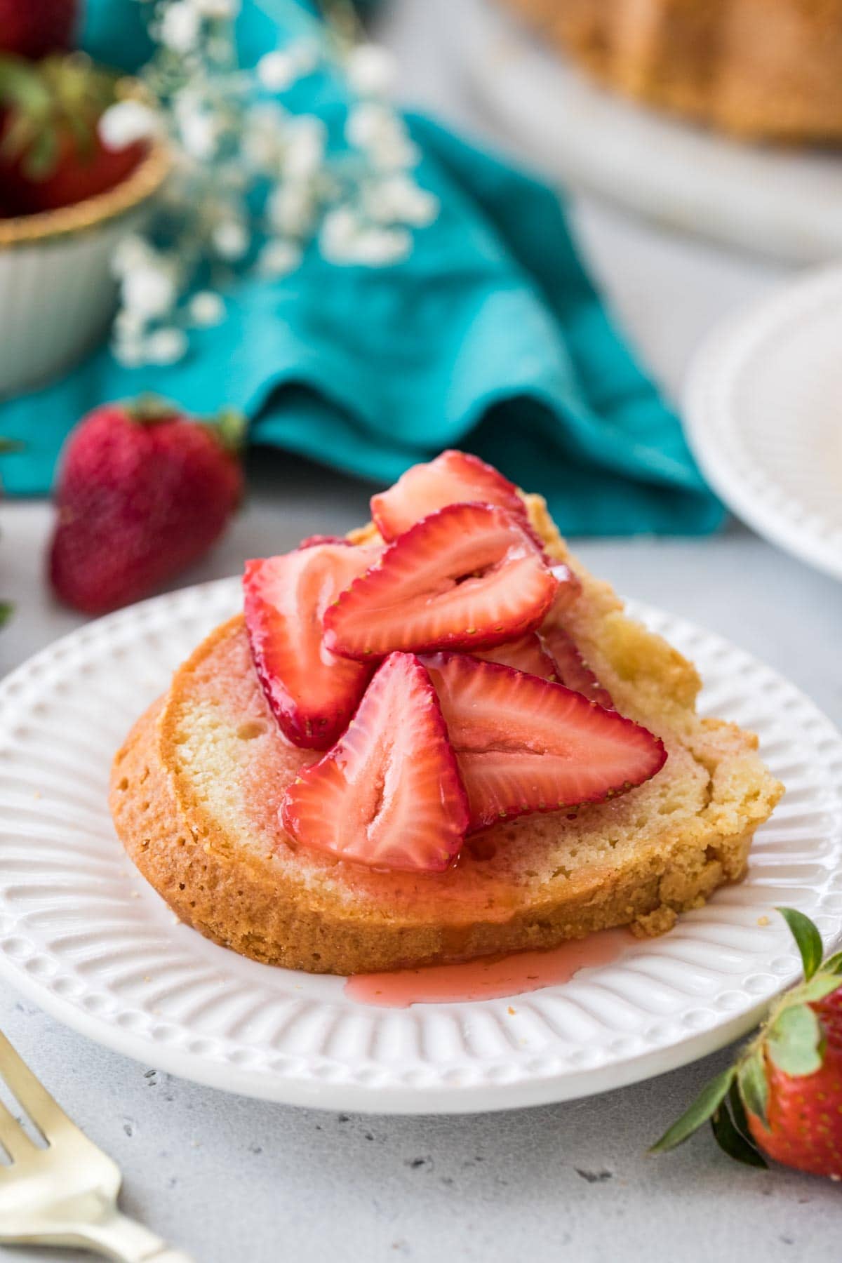 slice of pound cake topped with syrupy sliced strawberries