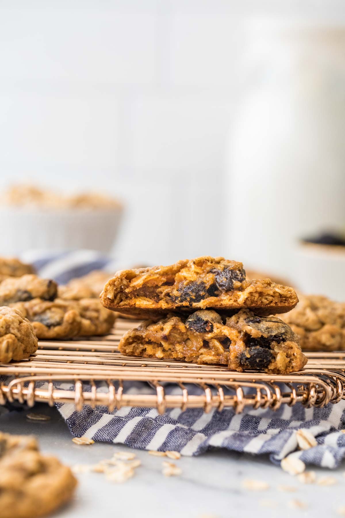 cross section of two halves of one cookie studded with raisins cooling on a metal cooling rack