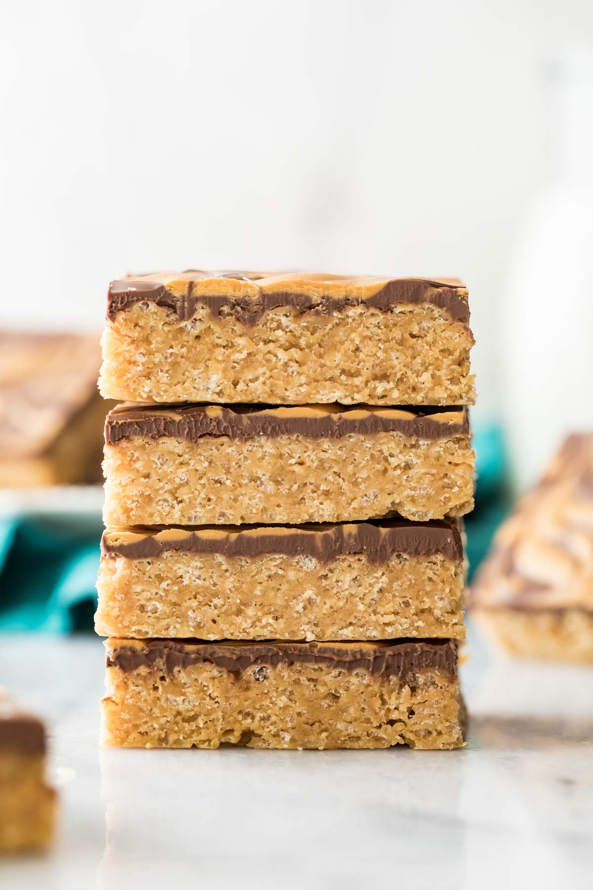 four neatly stacked peanut butter cereal bars topped with chocolate and butterscotch