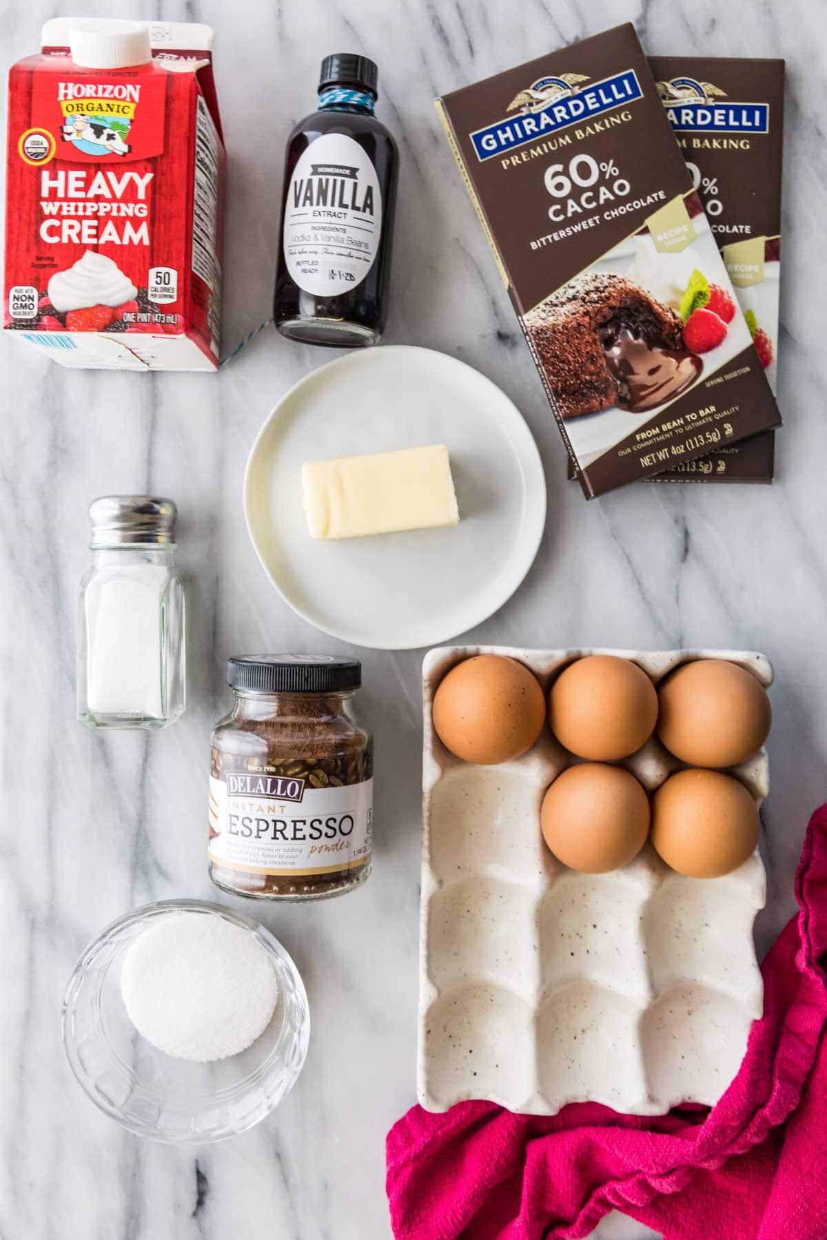 overhead view of ingredients including chocolate bars, heavy cream, espresso powder, eggs, and more