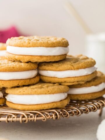 pile of peanut butter marshmallow sandwich cookies stacked on a metal cooling rack