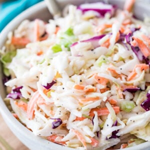 large bowl of homemade coleslaw full of shredded green and purple cabbage, carrots, and creamy dressing co