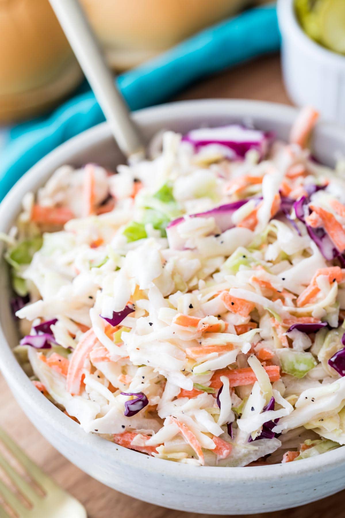 large bowl of homemade coleslaw full of shredded green and purple cabbage, carrots, and creamy dressing co
