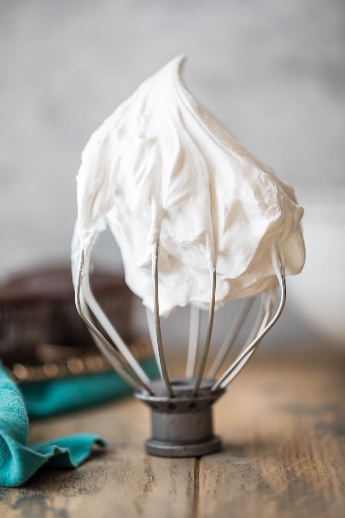 white mixer beater with white icing that's standing up to show stiff peaks