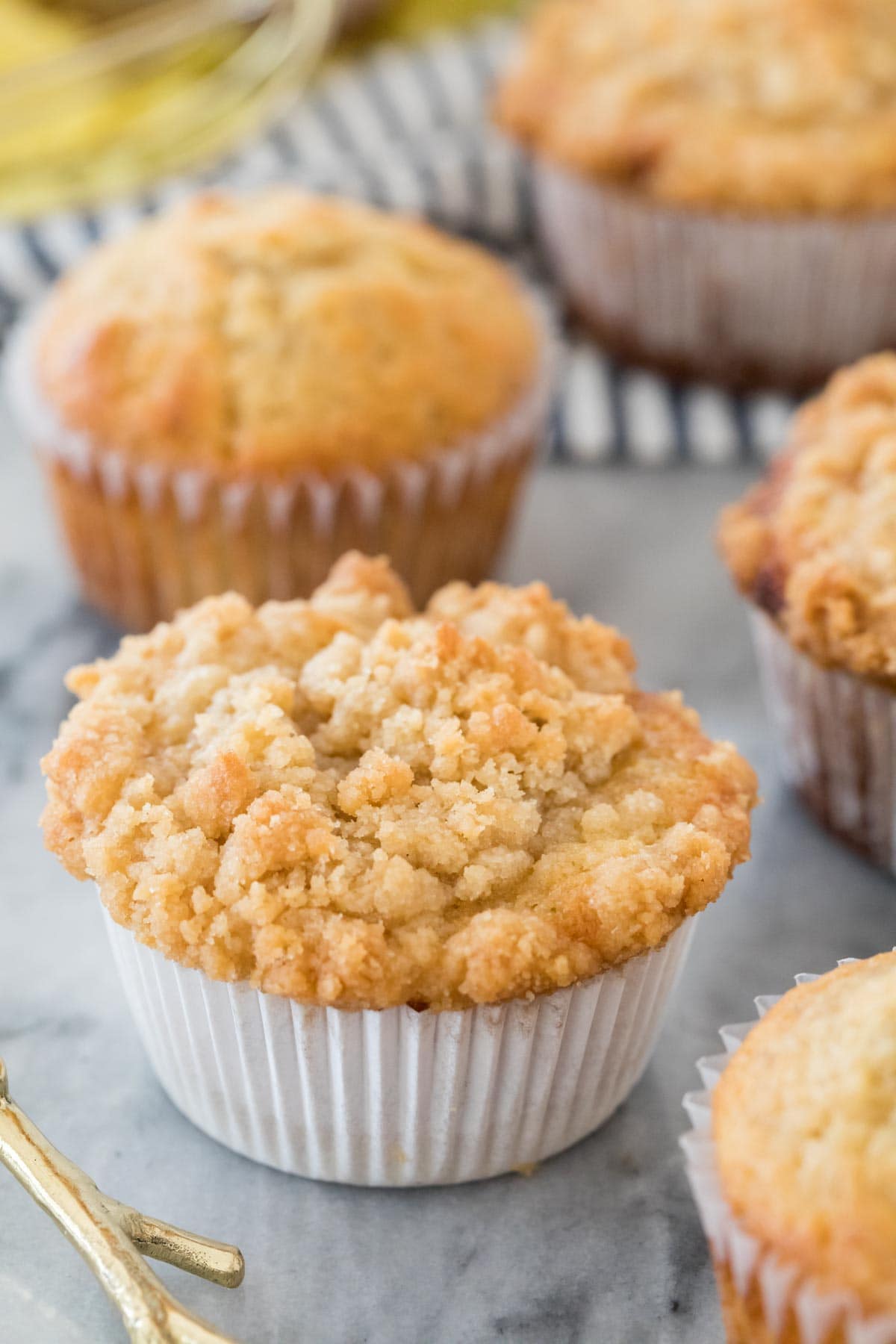 muffins with and without streusel scattered across a white marble counter
