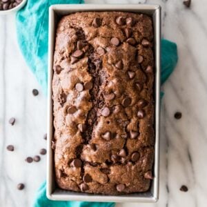 overhead view of a chocolate banana bread studded with chocolate chips in a metal loaf pan