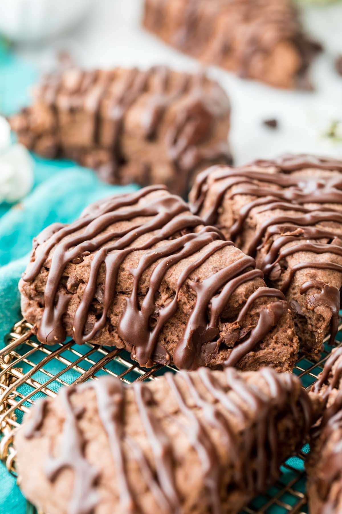 chocolate drizzled scones cut into wedges sitting on a metal cooling rack