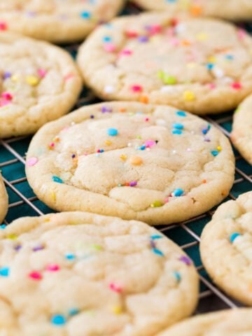 sprinkle-flecked funfetti cookies cooling on a cooling rack