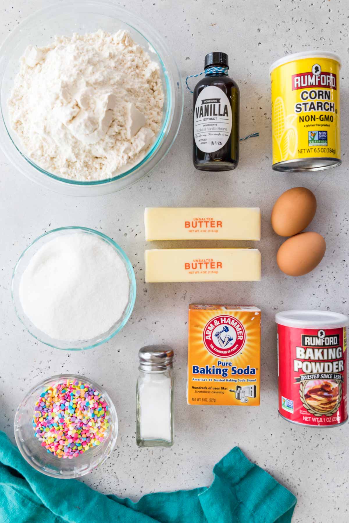 overhead view of ingredients including flour, vanilla, corn starch, sprinkles, and more