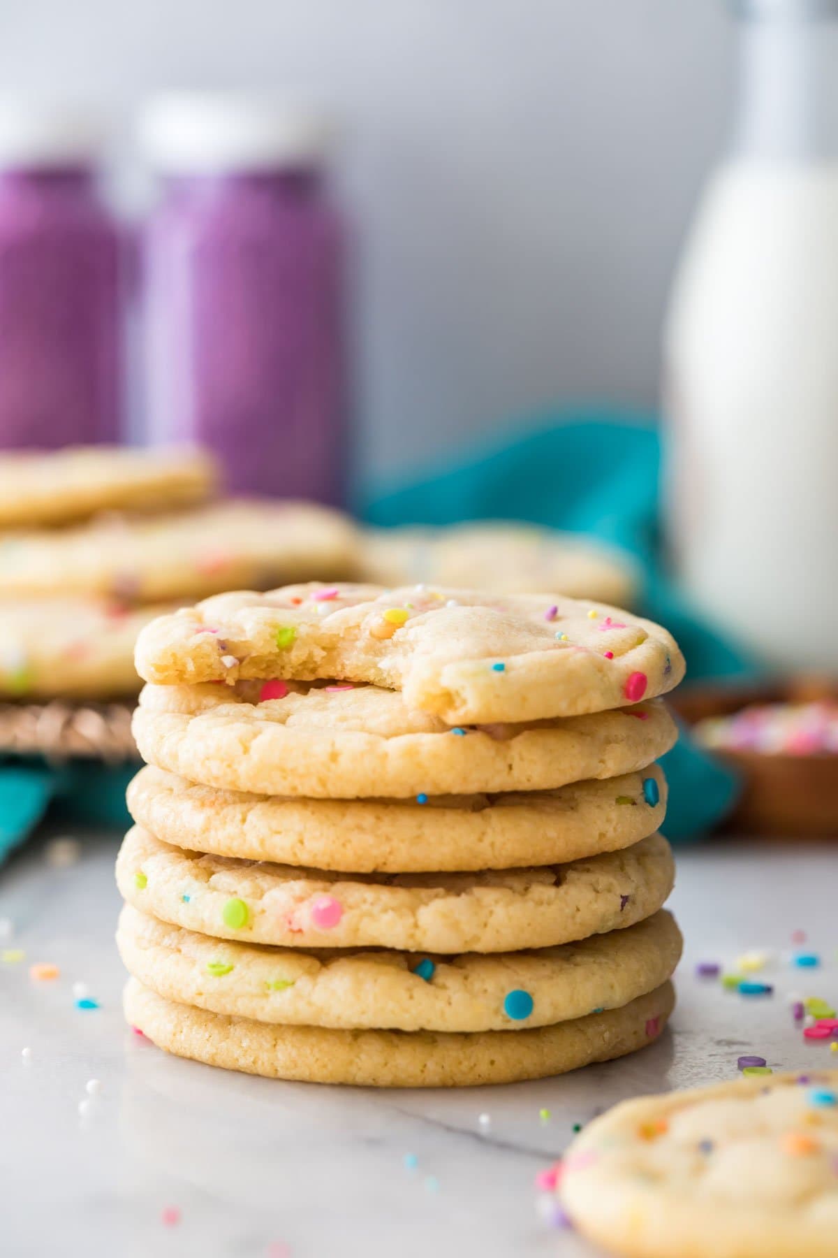 tall stack of round, sprinkle flecked cookies with the top cookie missing a bite