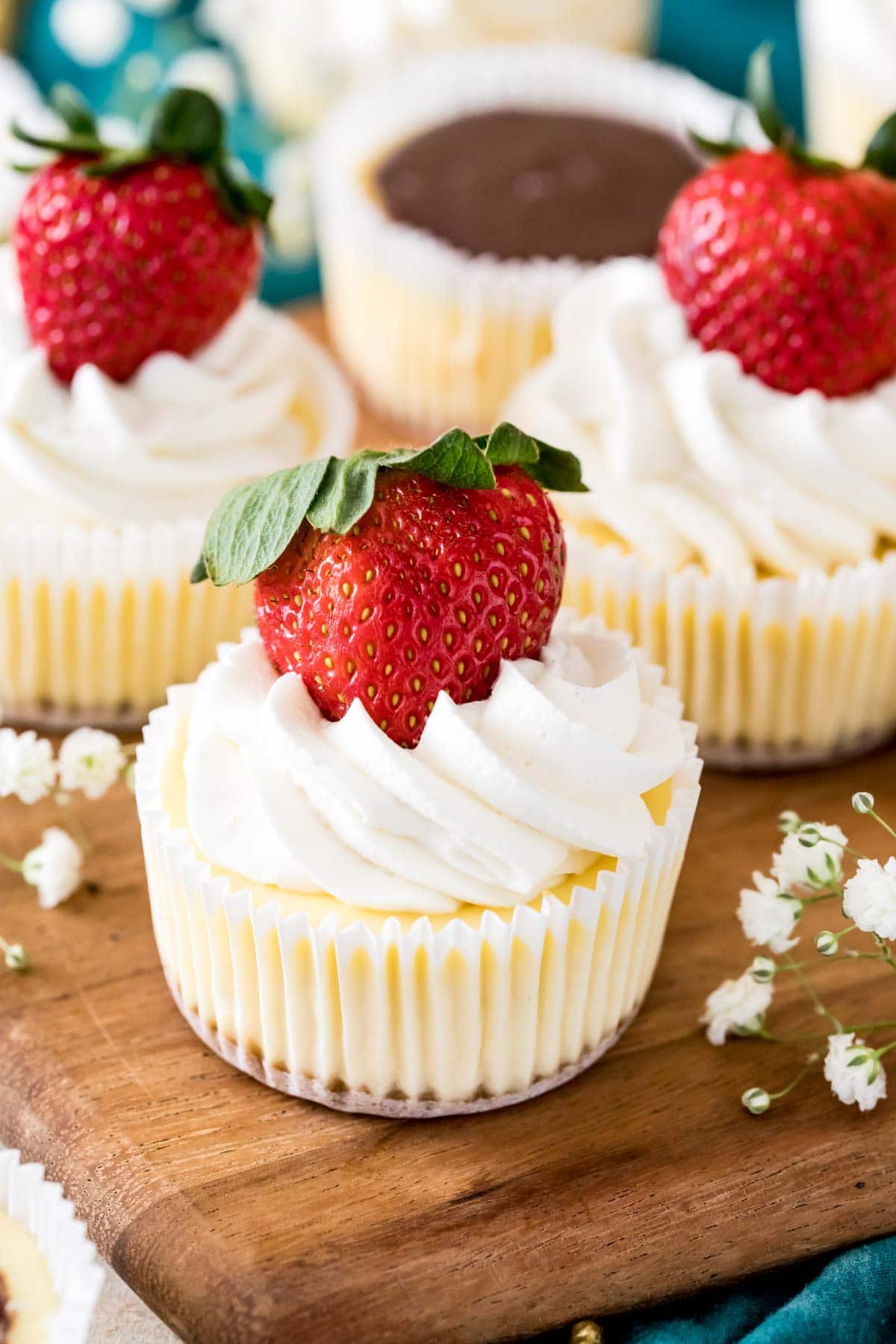 mini cheesecakes topped with whipped cream and a fresh strawberry