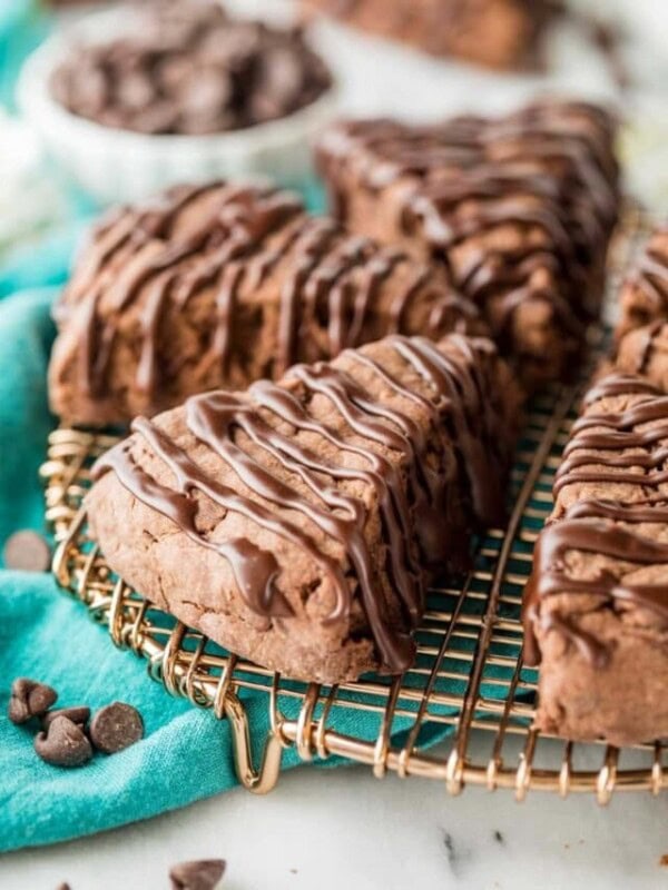 chocolate drizzled scones cut into wedges sitting on a metal cooling rack