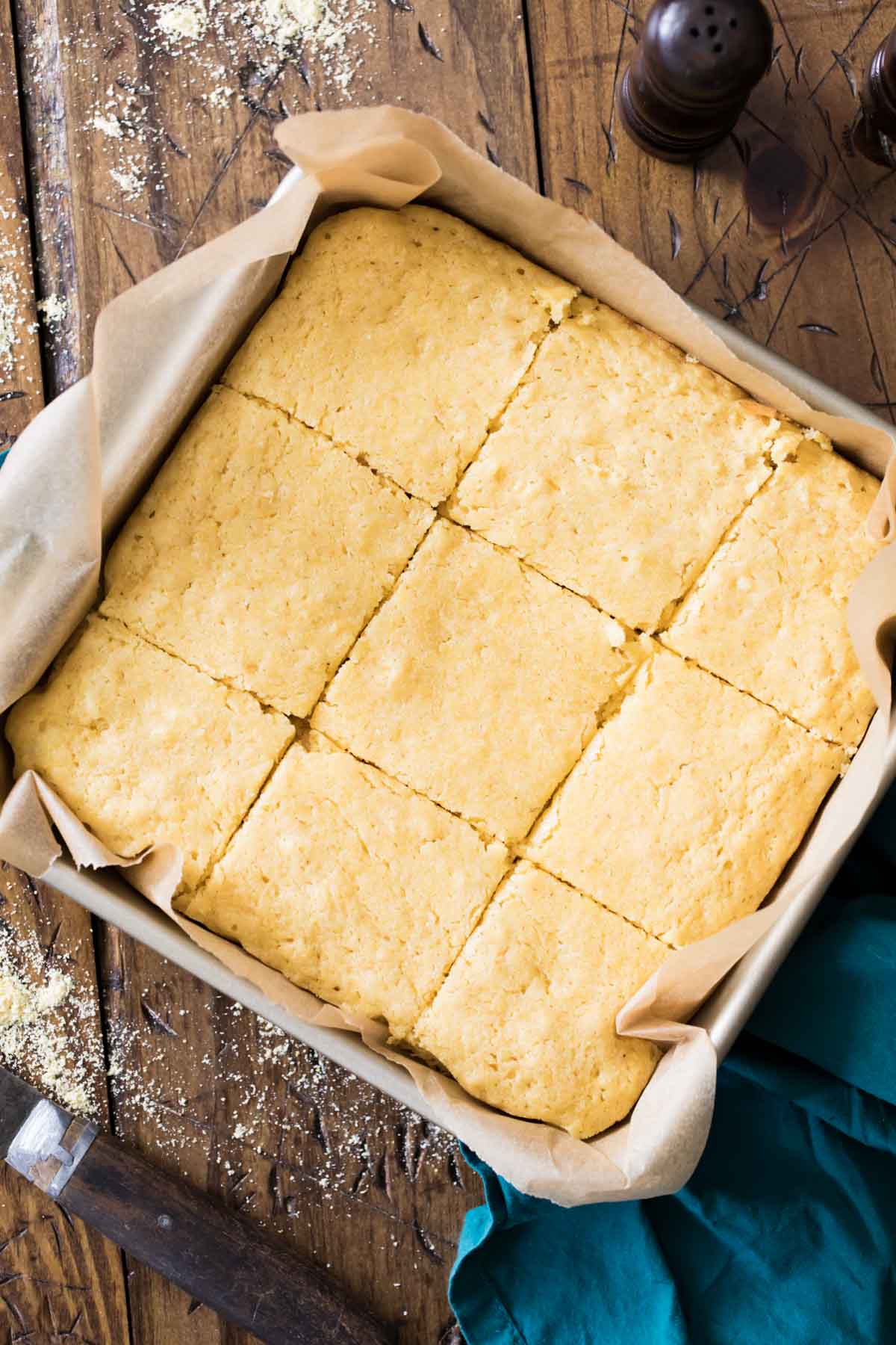 overhead view of a square pan of cornbread cut into 9 slices