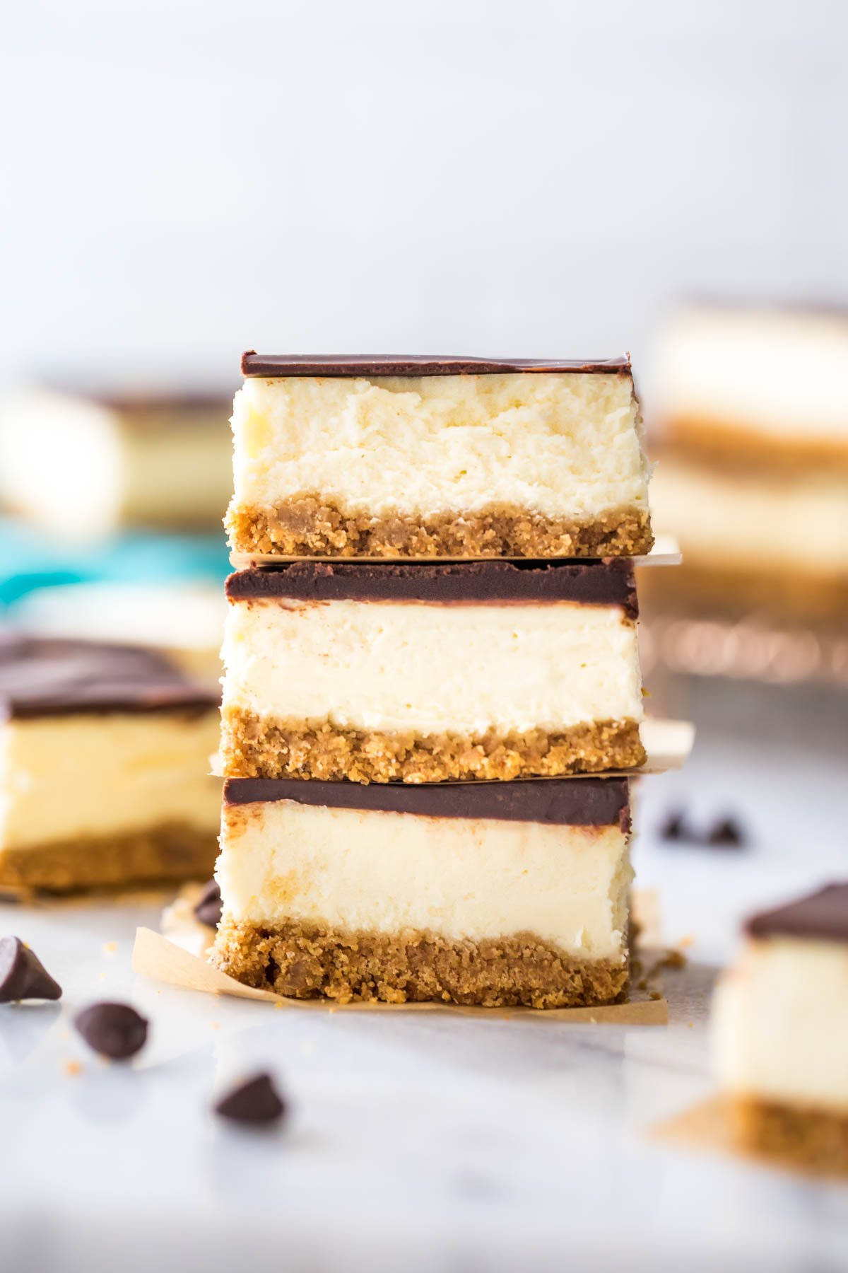 three ganache covered cheesecake bars stacked on top of each other