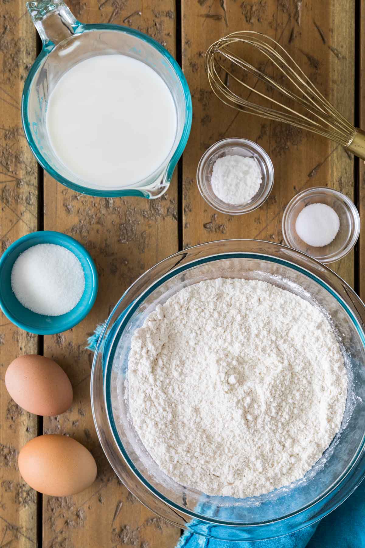 overhead view of ingredients including flour, eggs, milk, sugar, and more