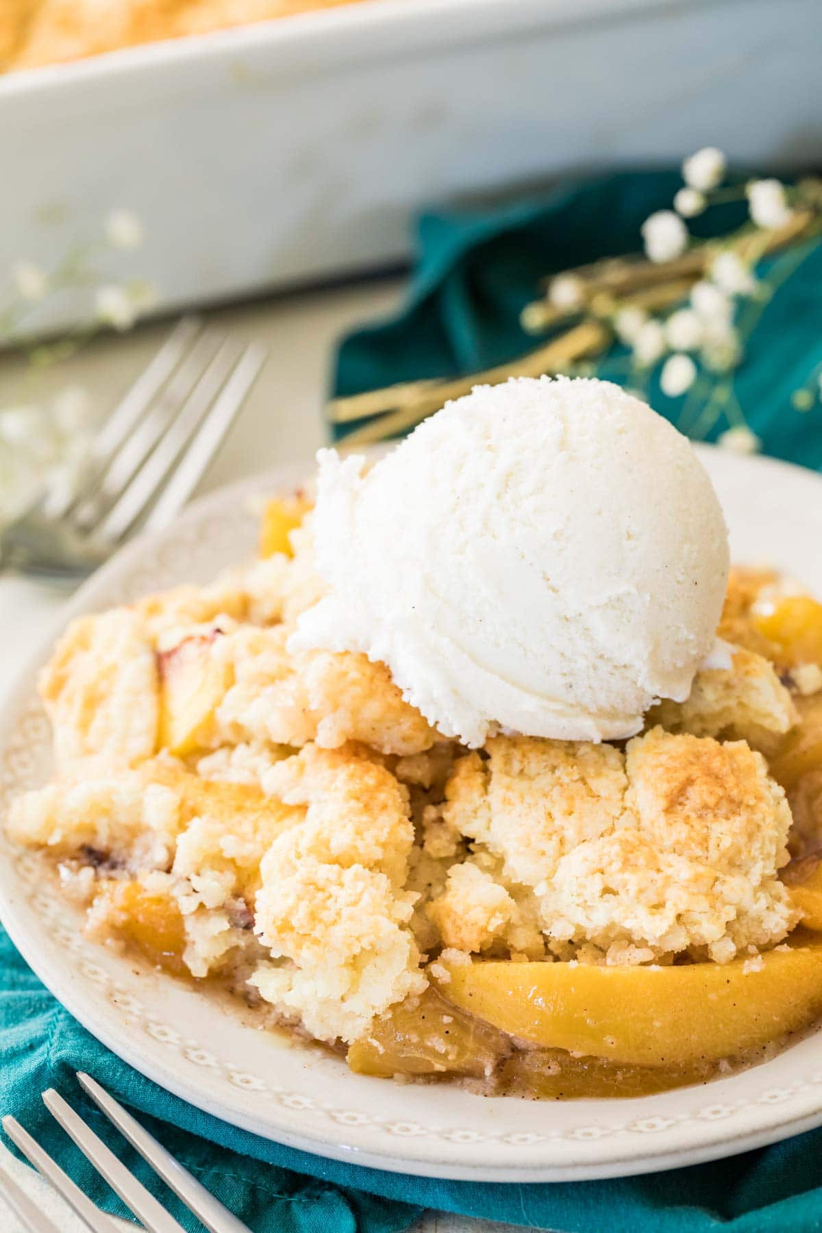 bowl of peach cobbler stopped with vanilla ice cream