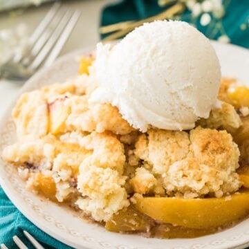bowl of peach cobbler stopped with vanilla ice cream