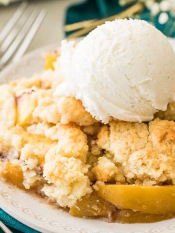 bowl of peach cobbler stopped with vanilla ice cream