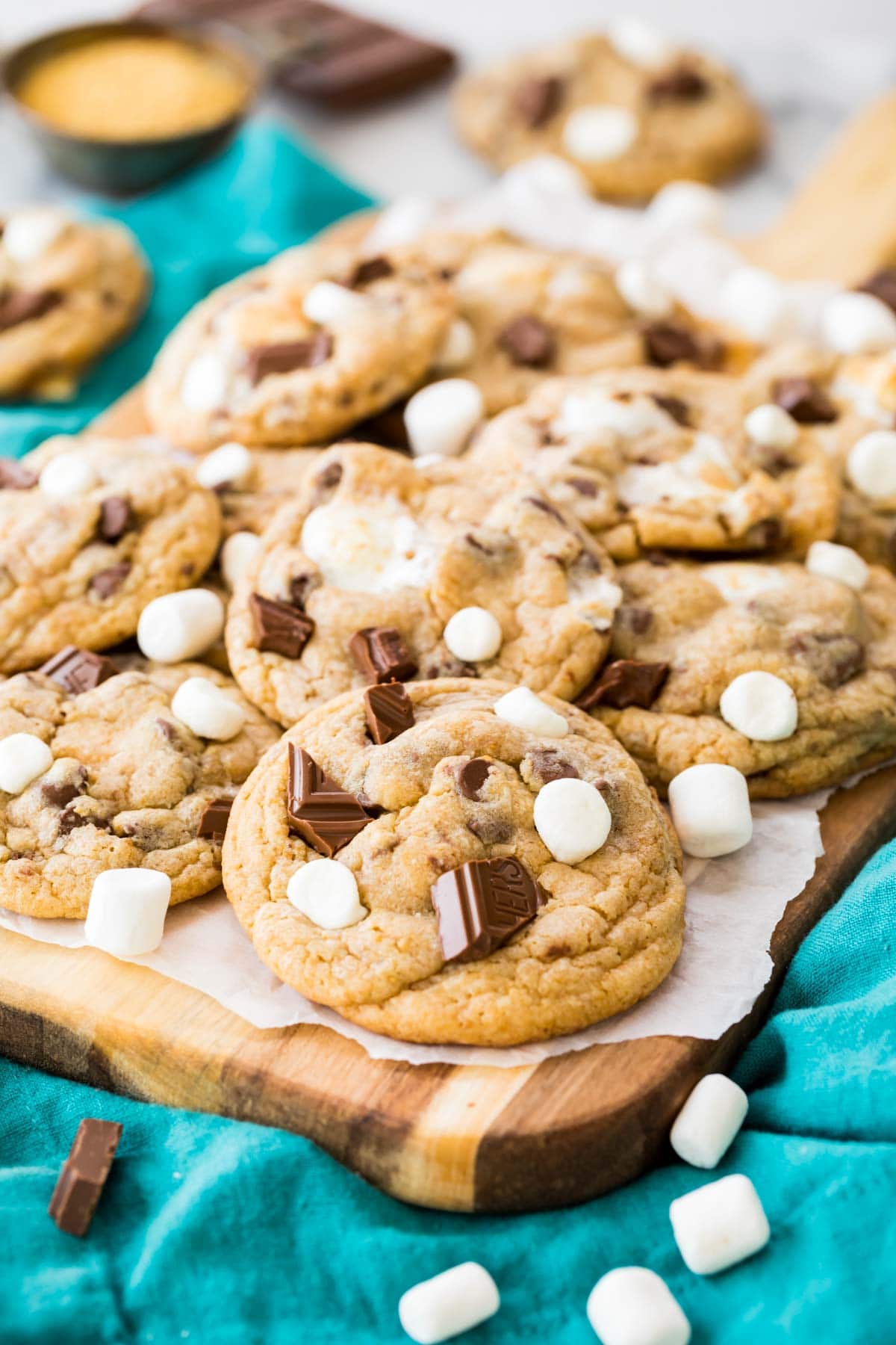 pile of cookies topped with marshmallows and broken chocolate pieces