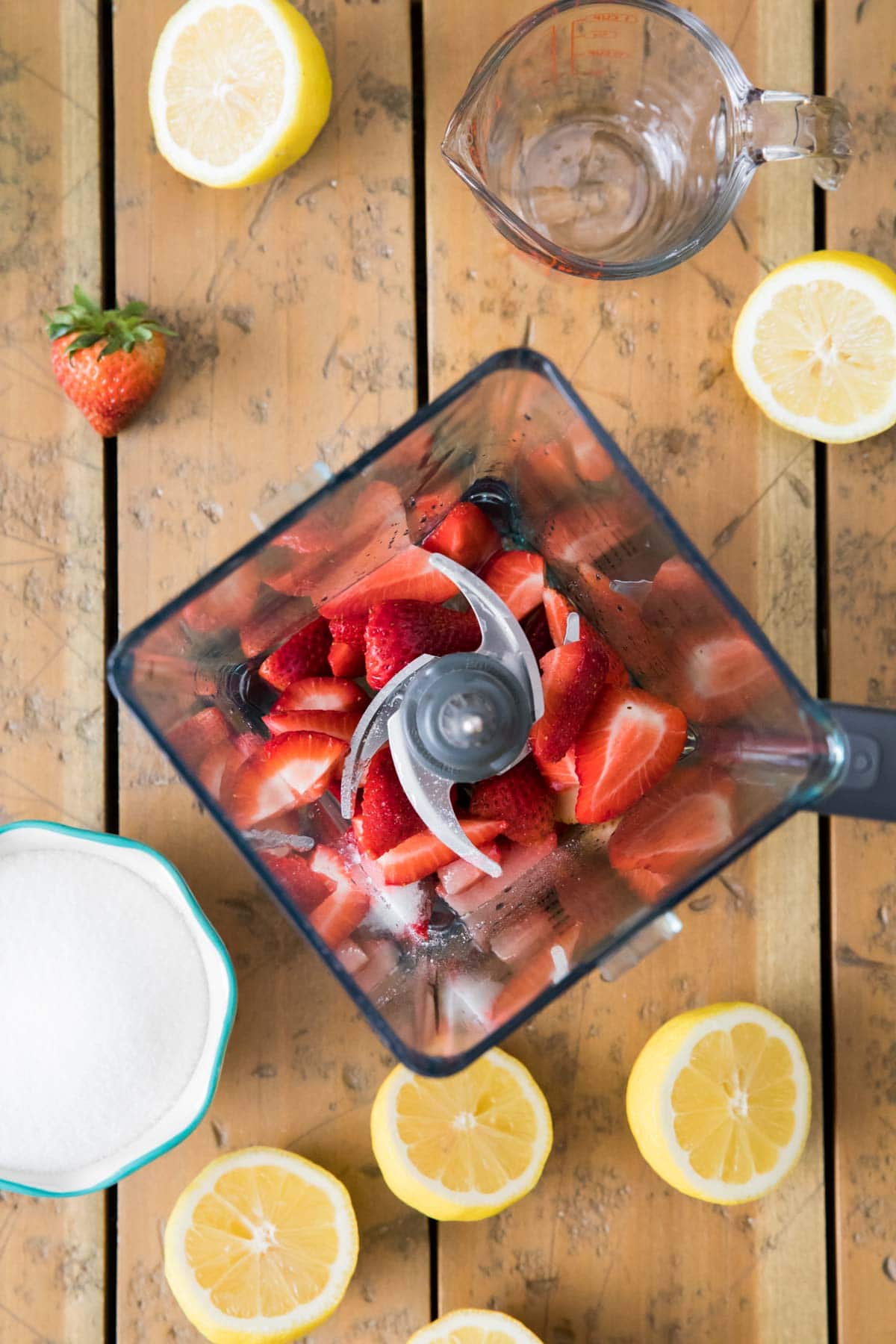 overhead view of strawberries in a blender before blending