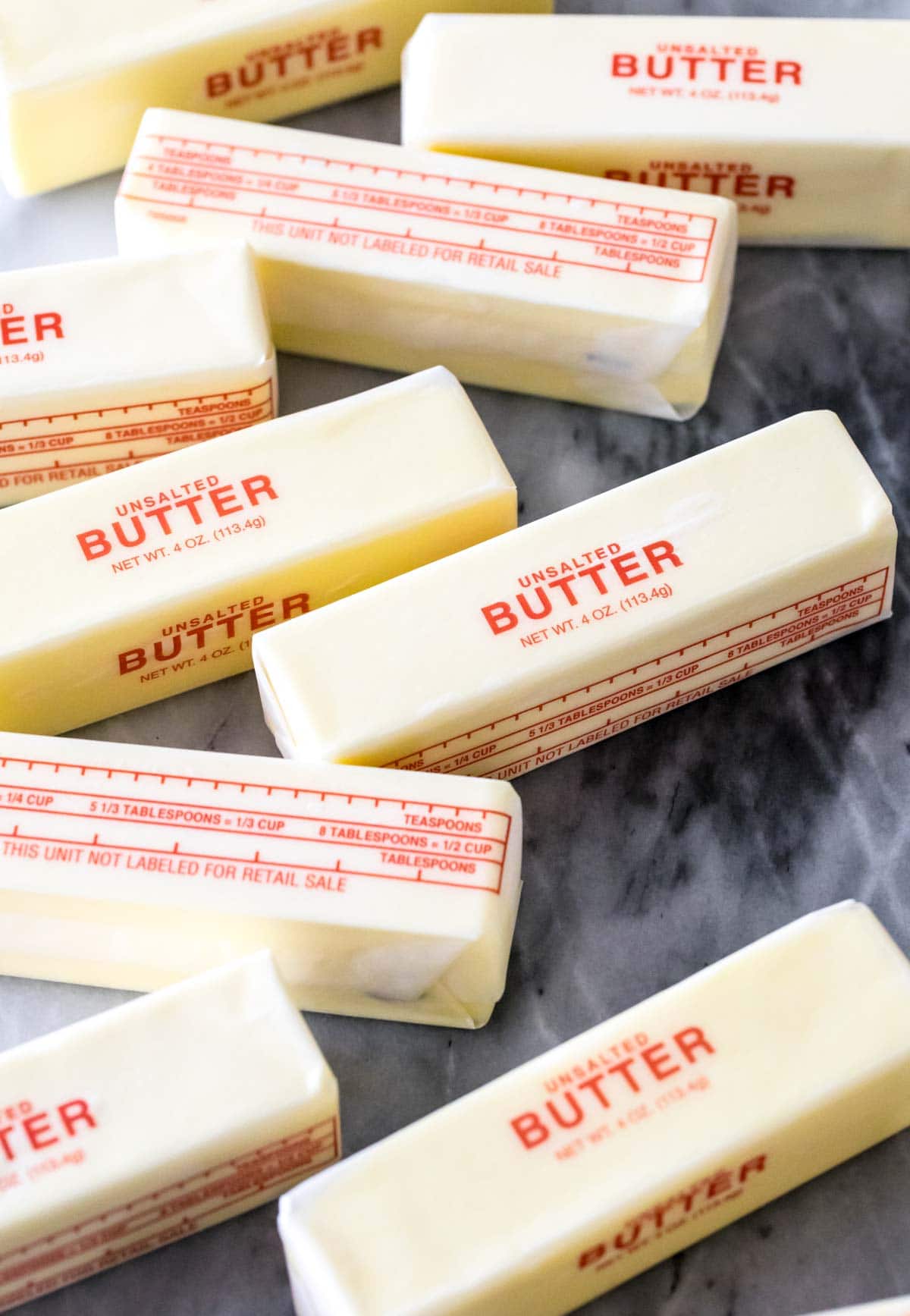 sticks of butter resting on a gray marble countertop