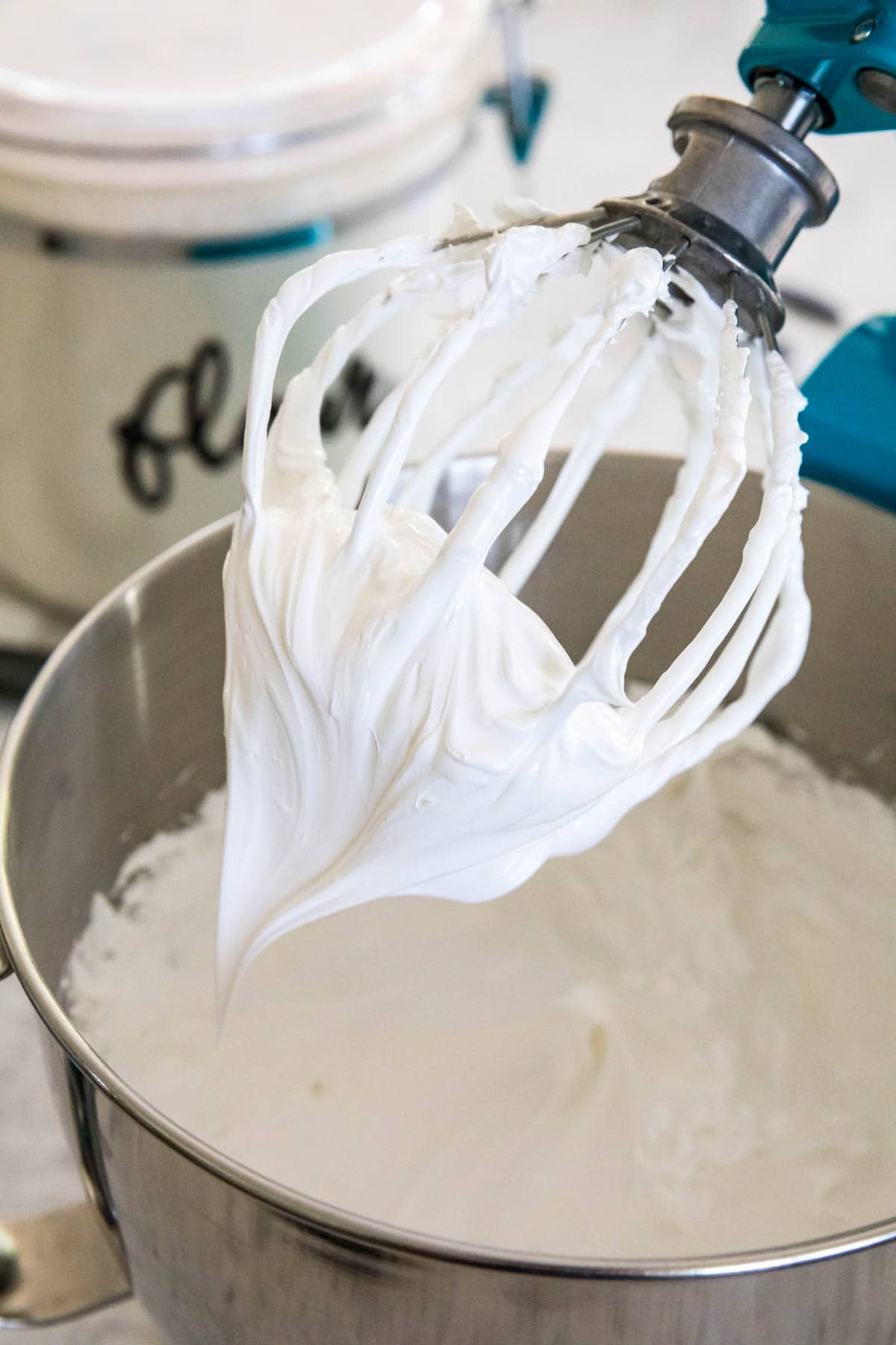 beater being lifted out of meringue to show stiff peaks