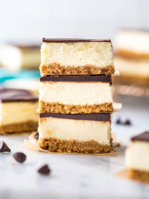 three ganache covered cheesecake bars stacked on top of each other