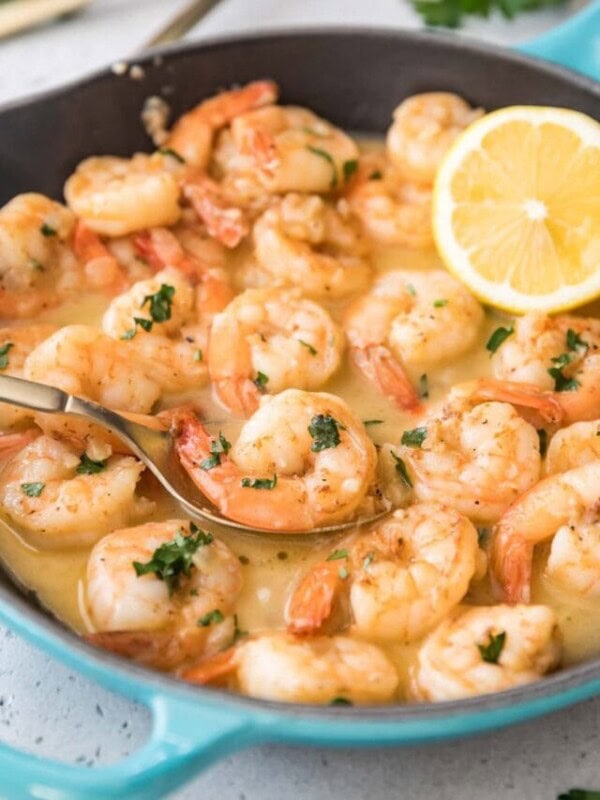 garlic butter shrimp being spooned out of a saucepan