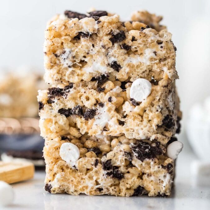 three stacked cookies and cream rice krispie treats studded with crushed oreos and mini marshmallows