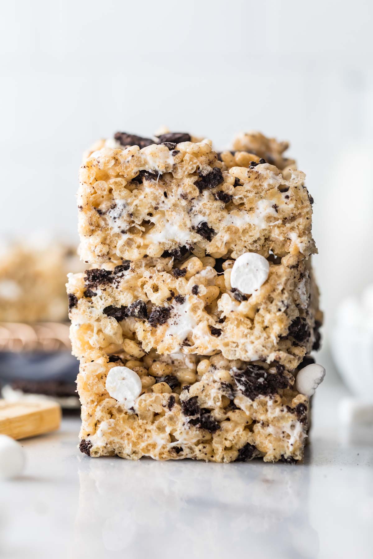 three stacked cookies and cream rice krispie treats studded with crushed oreos and mini marshmallows