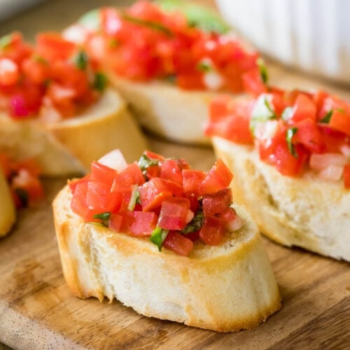 slices of bruschetta topped with chopped marinated tomatoes, basil, and garlic