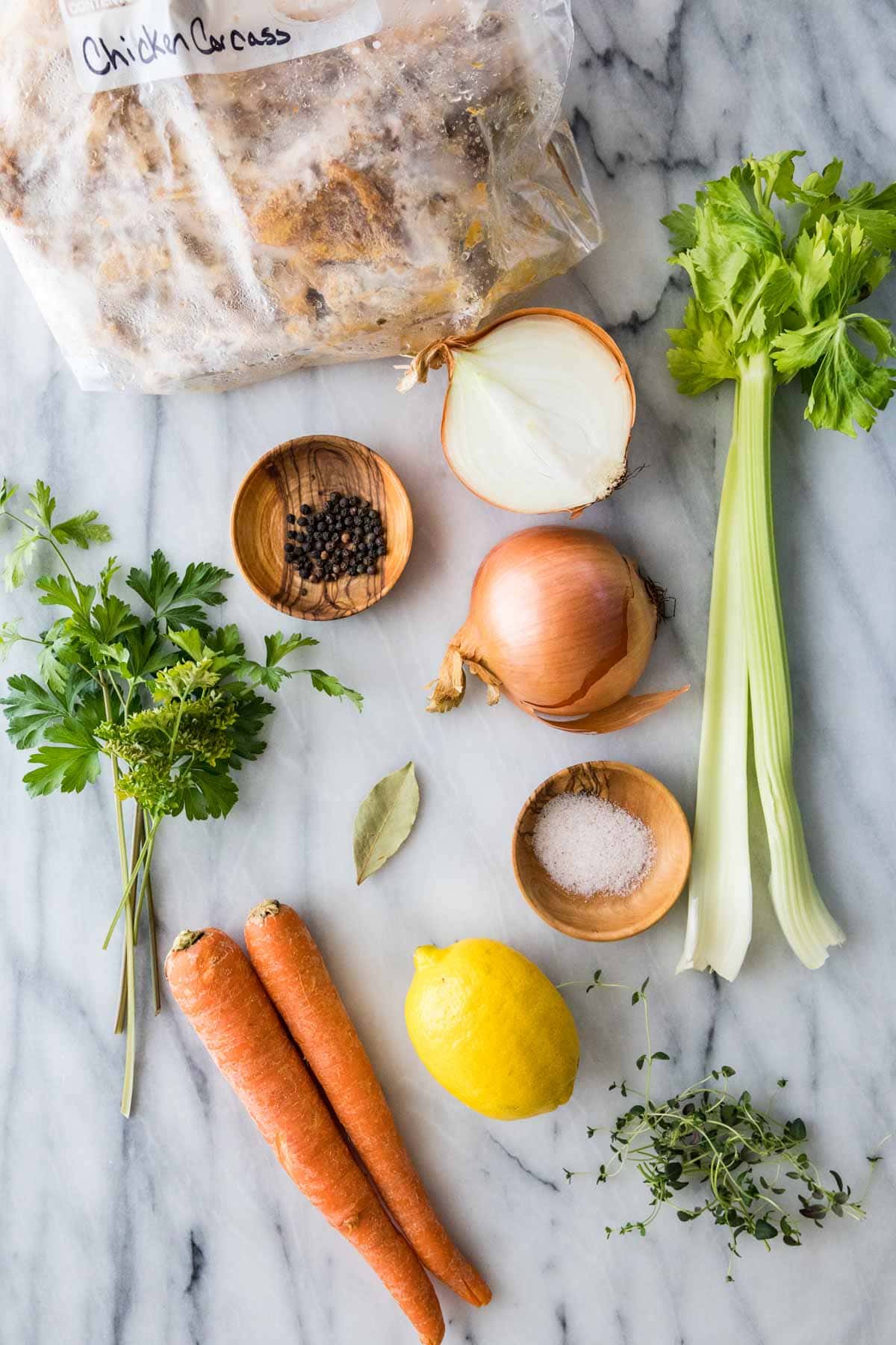 overhead view of ingredients including carrots, onion peppercorns, lemon, and more