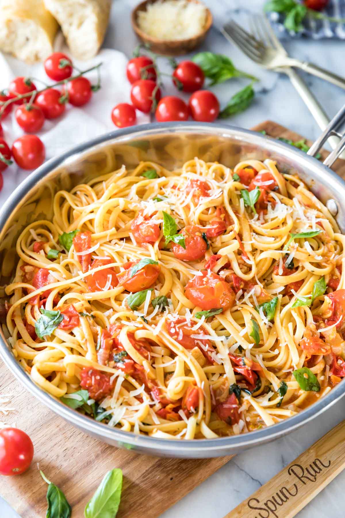 summer pasta with fresh cherry tomatoes and basil served in a stainless steel skillet