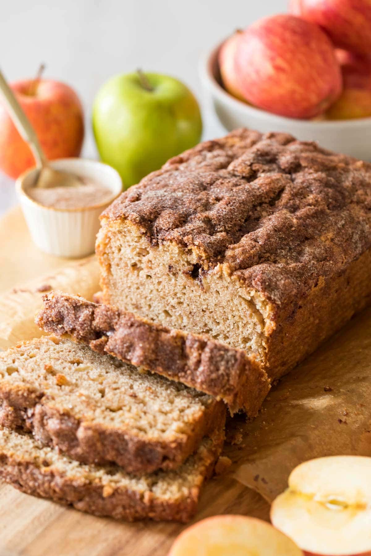 loaf of my baked apple bread recipe that's been sliced with three slices resting nearby