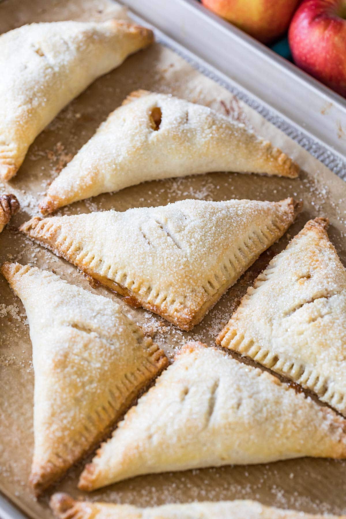 sugared apple turnovers on parchment paper after baking