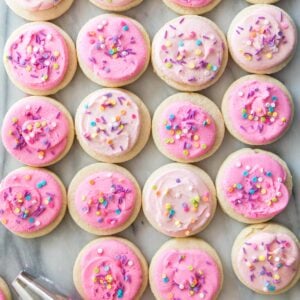 overhead view of homemade lofthouse cookies topped with varying shades of pink icing and sprinkles
