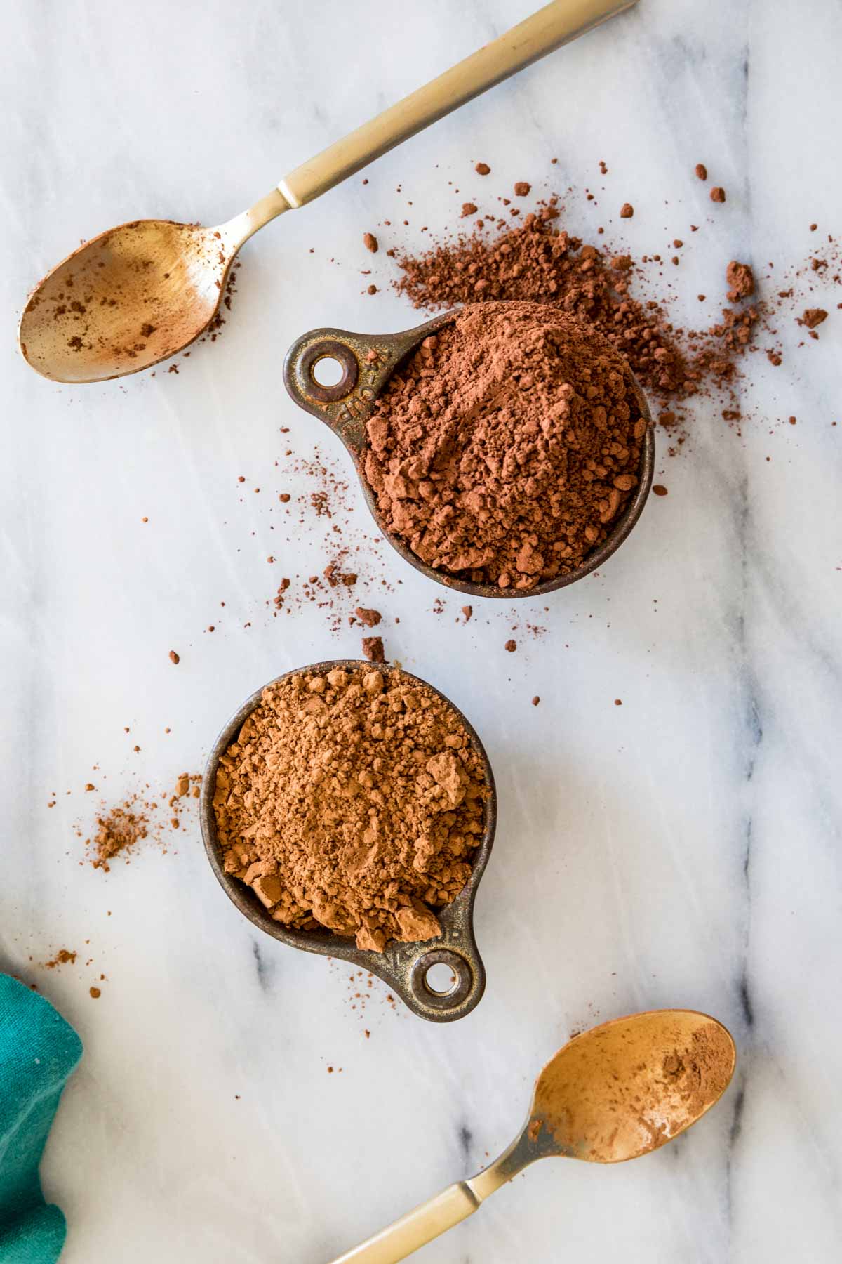 overhead view of two measuring cups comparing natural vs. dutch process cocoa