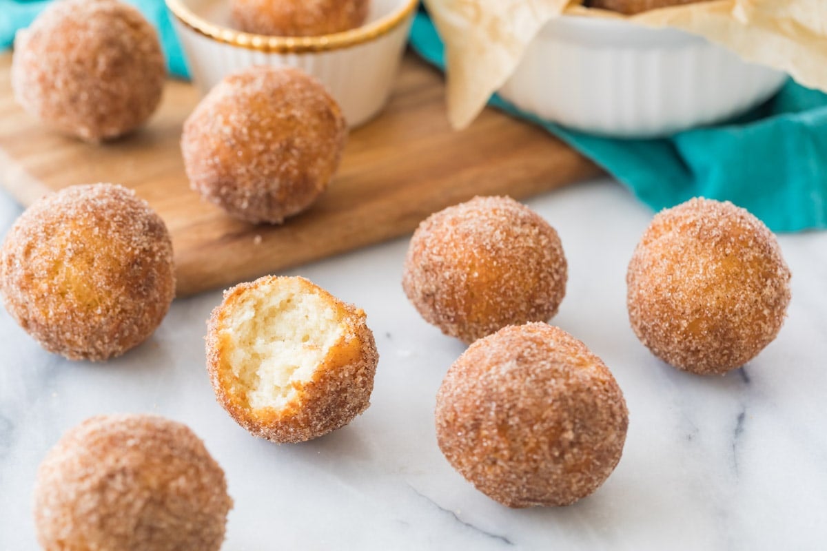 fried donut holes on a white marble counter