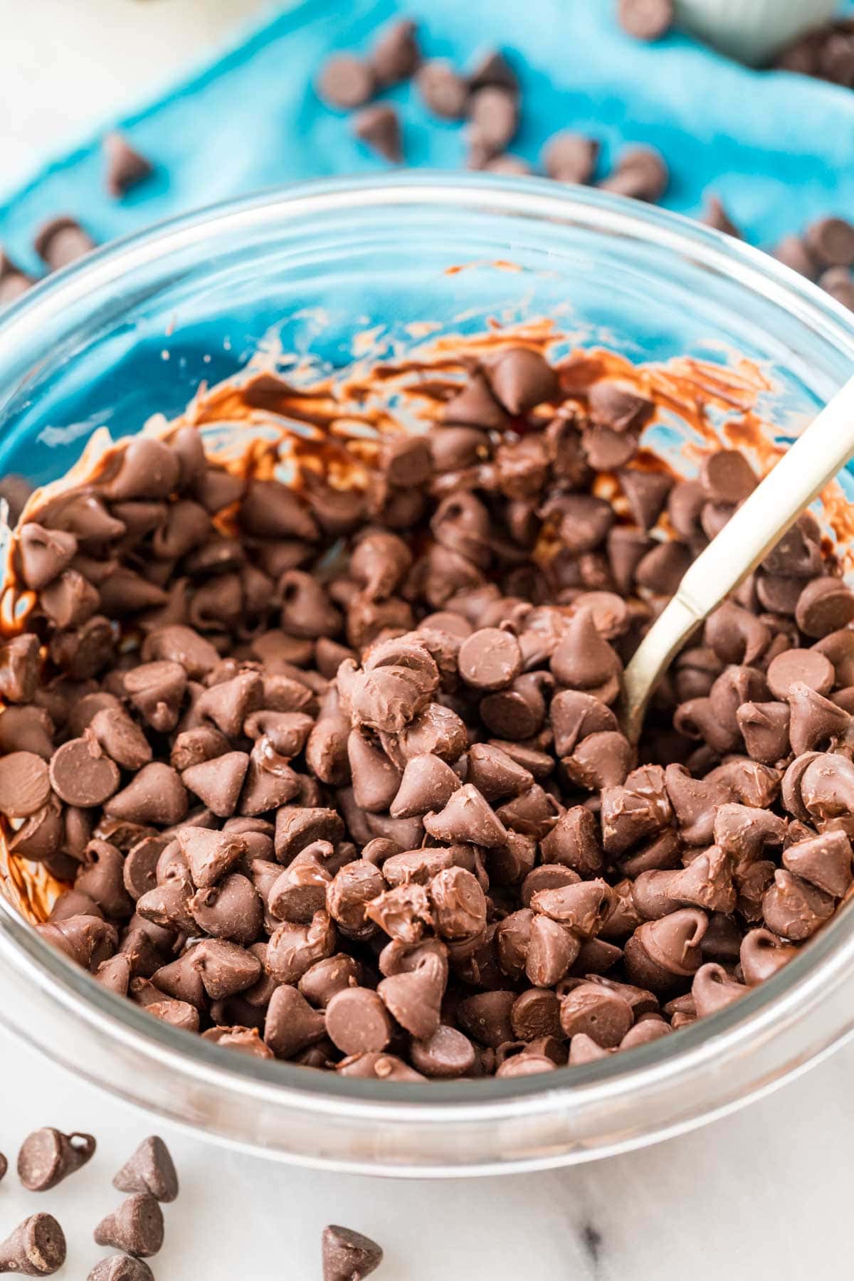 spoon stirring chocolate chips that are just starting to melt after microwaving