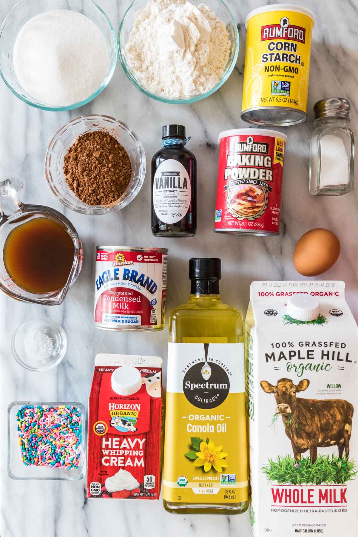 overhead view of ingredients including flour, cocoa powder, milk, vanilla sprinkles, and more