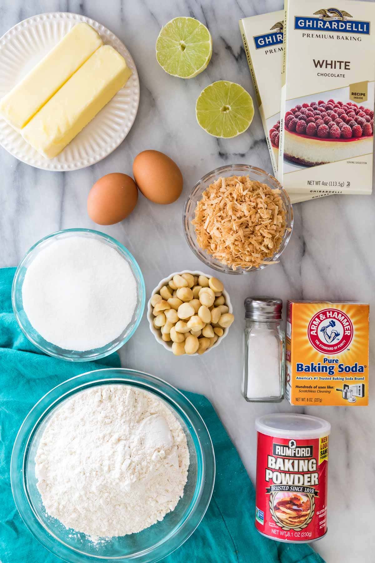 overhead view of ingredients including white chocolate bars, limes, toasted coconut, butter, and more