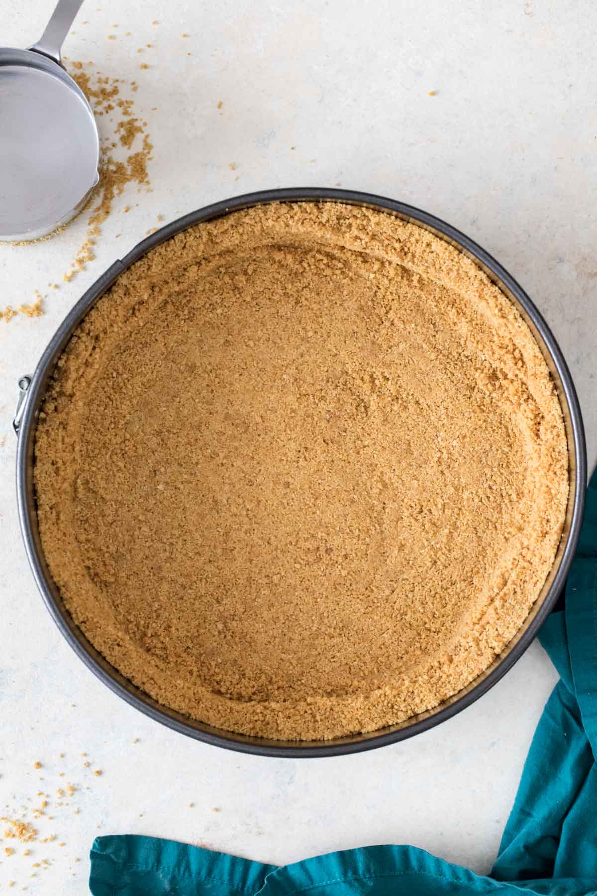 overhead view of a graham cracker crust pressed into a springform pan