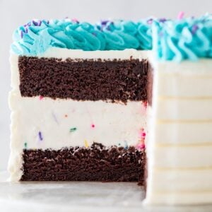 close-up view of the interior of an ice cream cake made with chocolate cake, vanilla ice cream, and turquoise whipped cream frosting