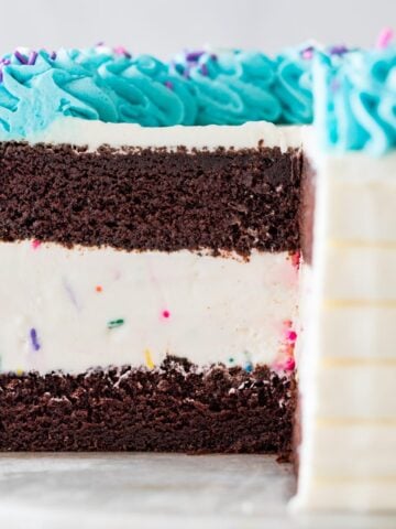 close-up view of the interior of an ice cream cake made with chocolate cake, vanilla ice cream, and turquoise whipped cream frosting