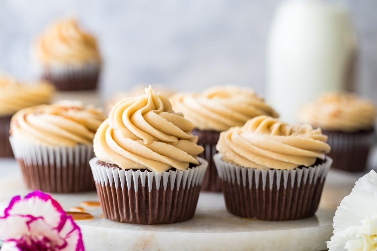 cupcakes frosted with piped frosting, with the left cupcake generously frosted