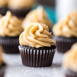 Mini dark chocolate cupcake topped with caramel frosting and sea salt.