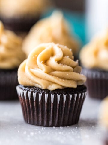 Mini dark chocolate cupcake topped with caramel frosting and sea salt.