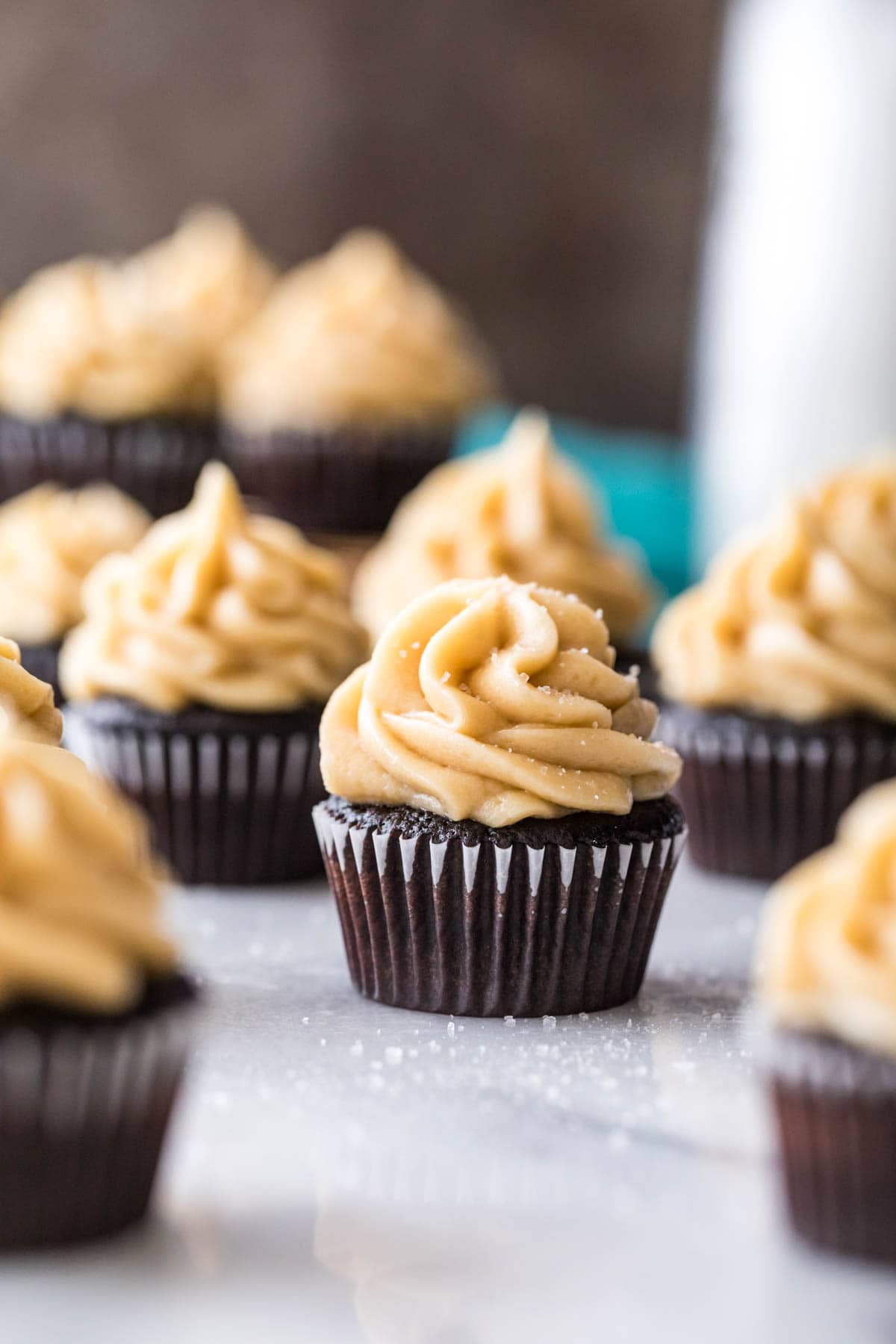 Mini dark chocolate cupcake topped with caramel frosting and sea salt.