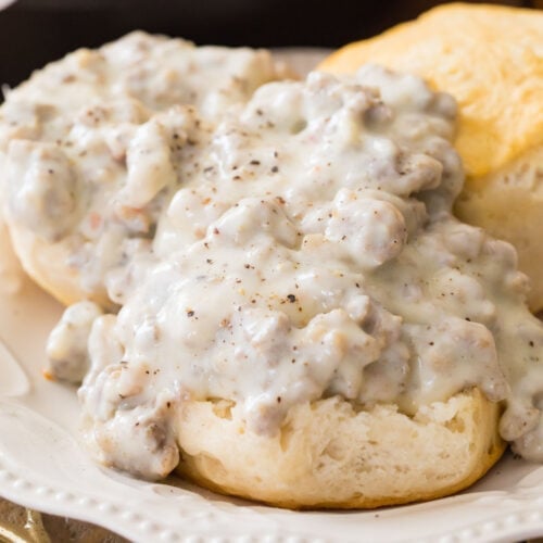 Sausage gravy recipe poured over open faced biscuits