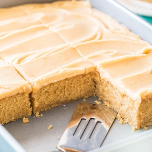 Peanut butter sheet cake that's been frosted and sliced in its pan.